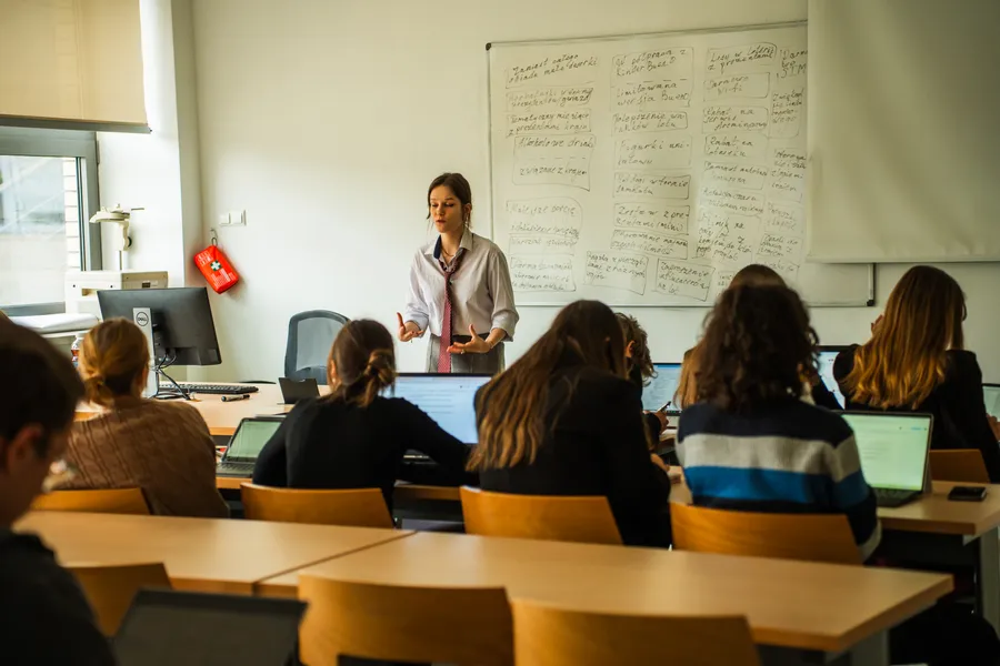 Mówczyni MPDO przemawia przed salą z rozpisaną na tablicy argumentacją