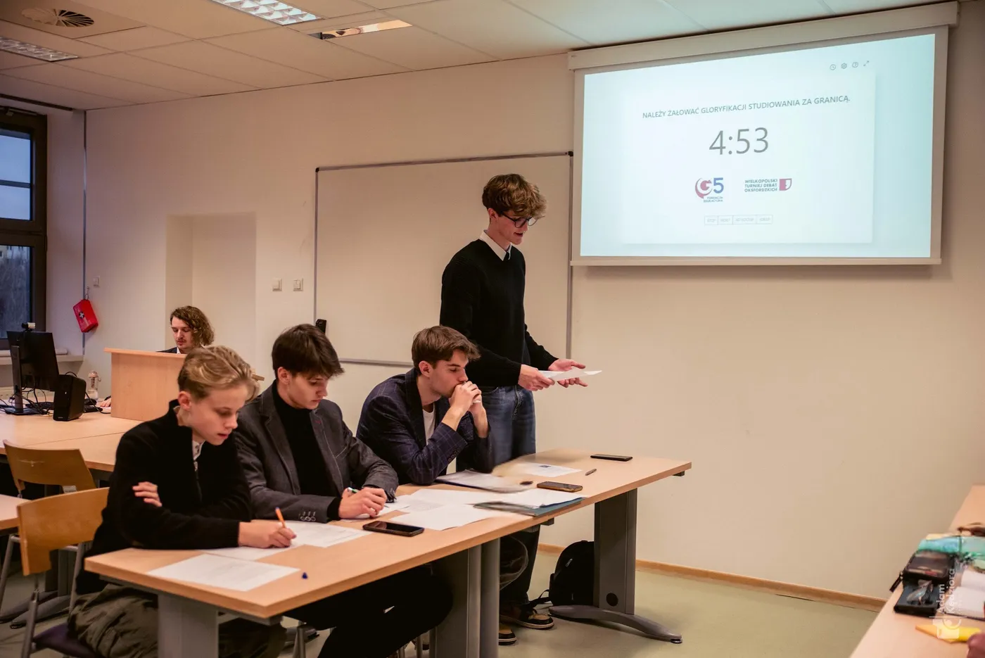 Mówca WTDO 2024 podczas wystąpienia, na ekranie teza finałowa i logo turnieju